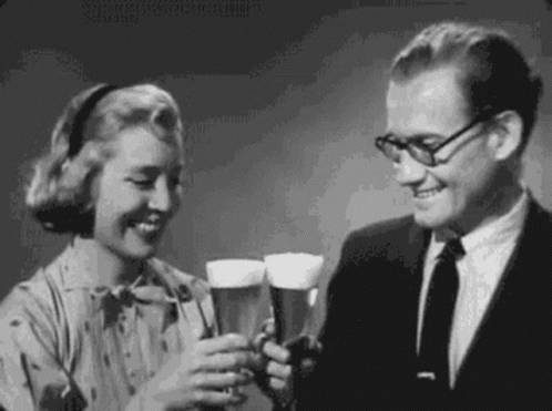 an old po of two people holding beers
