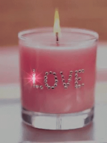 a purple candle that says love sitting on a table