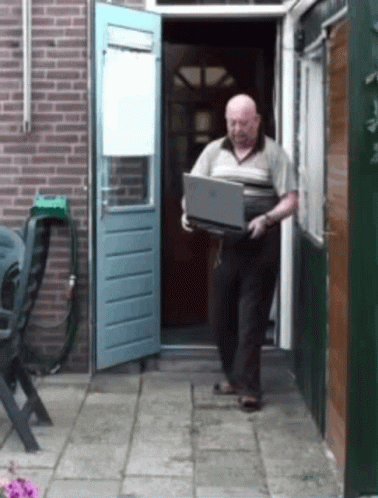 an older man is carrying a box out the back door