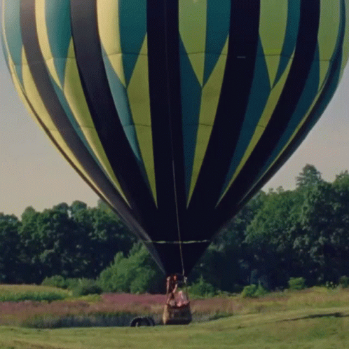 two men are sitting in the seat of a big  air balloon
