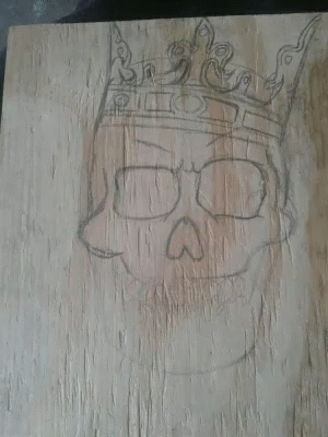 the drawing on the wooden shows the skull with a crown on it