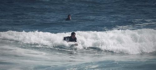 two surfers are riding small waves in the ocean