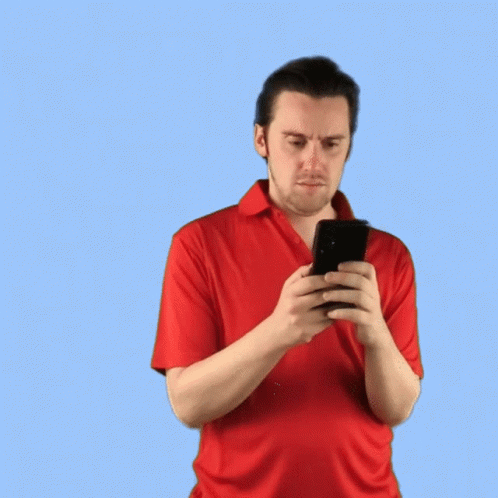 a man in a blue shirt looking at a phone
