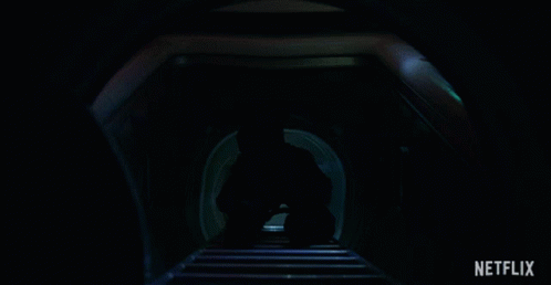 a person walking down a hallway in the dark