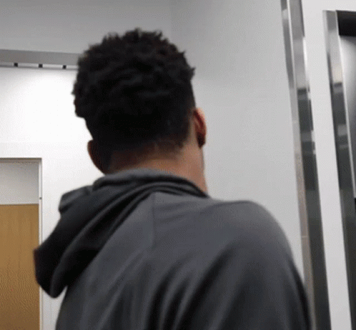 a man looks at his reflection in the bathroom mirror