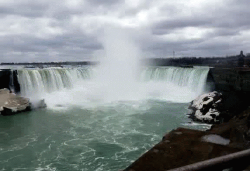 a waterfall pouring out of the water into a lake