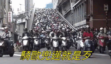 a large crowd of motorcyclists pass each other on a city street
