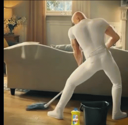 a person in a full body white outfit in the living room with cleaning products