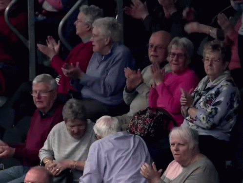 elderly people are sitting and waving while they look on