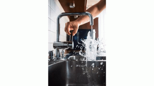 a man washing his hands under the faucet