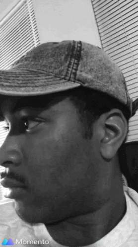 a black and white po of a man wearing a cap