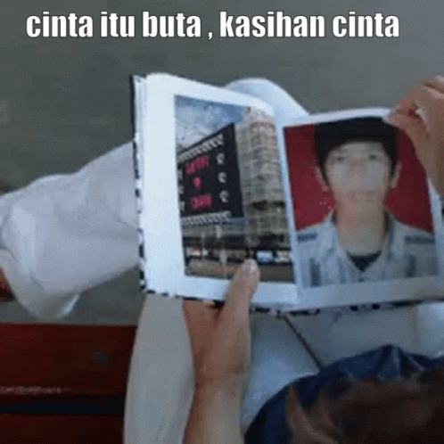 a person in white sweater holding a book with a picture of him