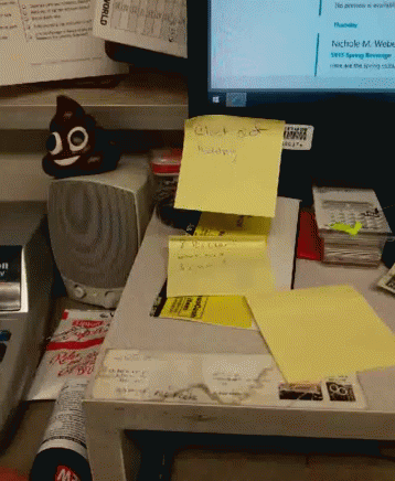 an open laptop on top of a desk covered in sticky notes