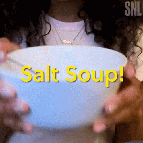 a woman holds a bowl of salted up food
