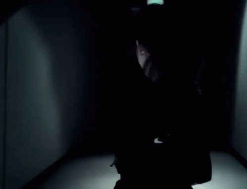 a person with a suitcase in a dark room