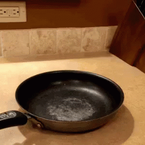a frying pan with two forks is on the counter