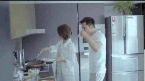 a couple of men in white outfits are preparing food