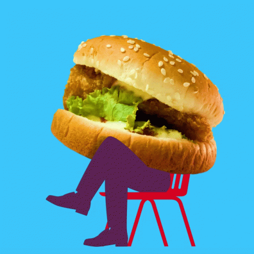 a person that is sitting down with a hamburger sandwich in it