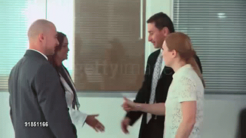 two males talking to a woman in an office