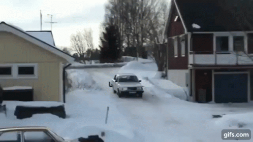 a car that is driving through snow with a house