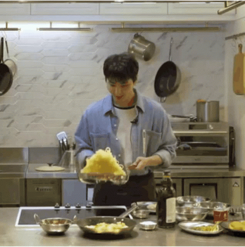a man cooking a lot of food in a kitchen