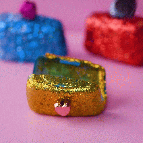 three glittered purses sitting on top of a table
