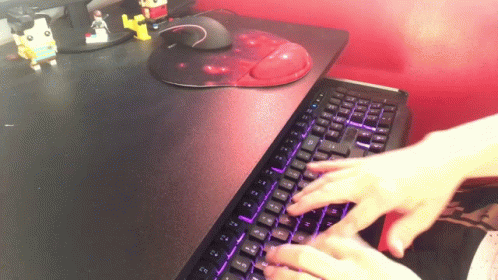 a person typing on a black computer keyboard