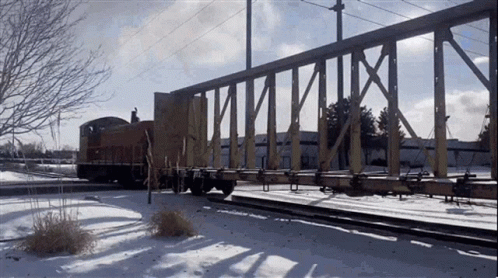 train on tracks crossing over a bridge with snow