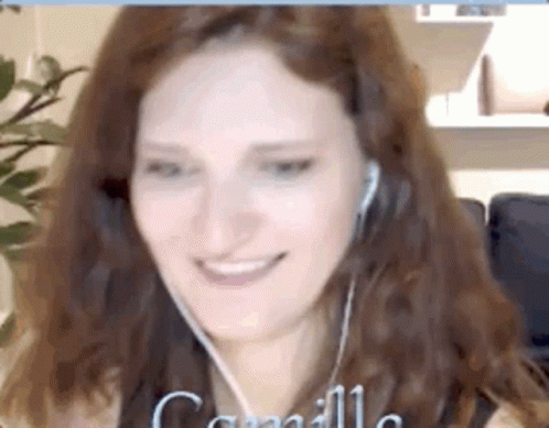 a woman smiles while holding a video clip