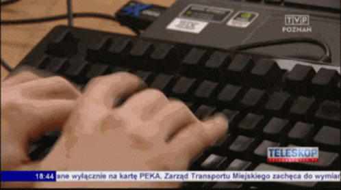 a person typing on a computer keyboard and mouse