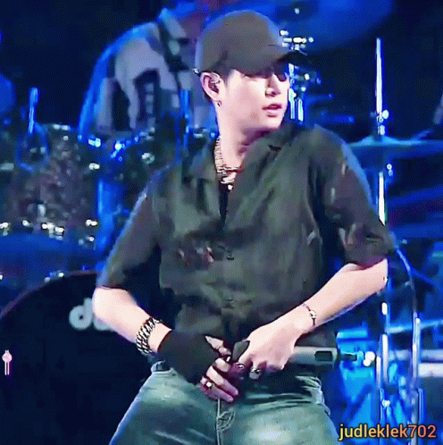 a man on stage with his hands in his pockets