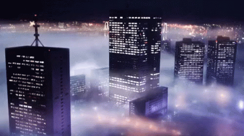 many tall buildings towering above the clouds with night lights