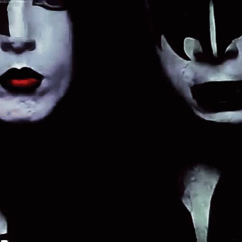 the two woman are wearing masks with faces painted white