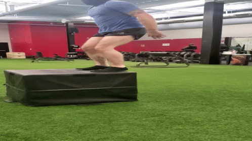 a man is doing tricks on a suitcase in an exercise room