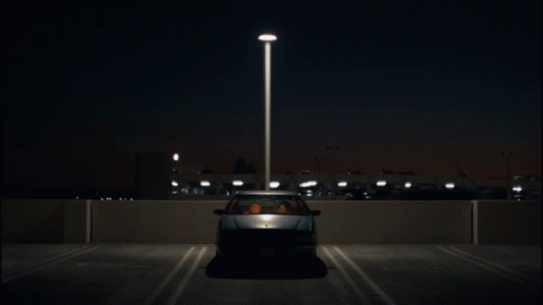 a car driving down the road at night time
