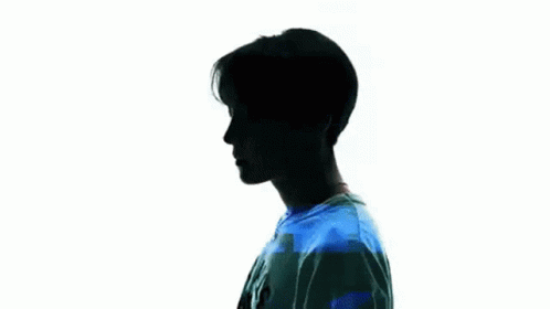 silhouette of a young man standing looking at the camera