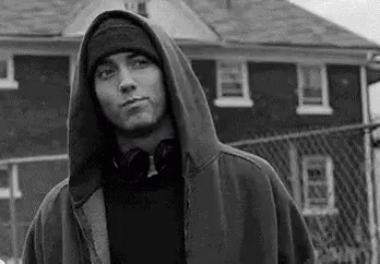young man dressed in hoodie and holding a skateboard