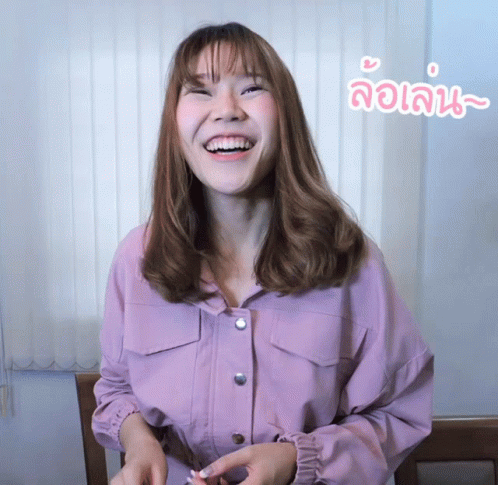 a woman in pink shirt making funny face with hands