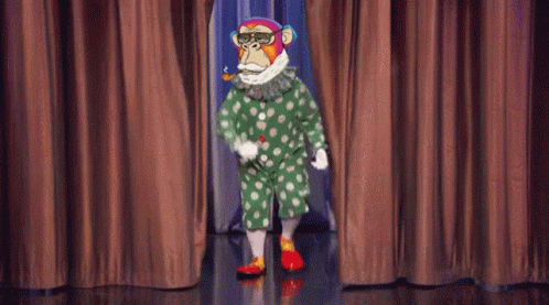a clown is standing on a stage with blue curtains