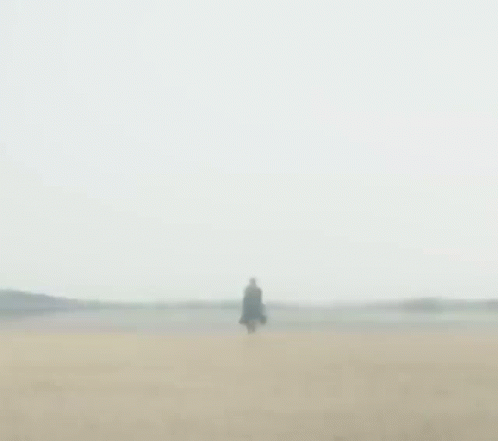 a person walking in a large blue body of water