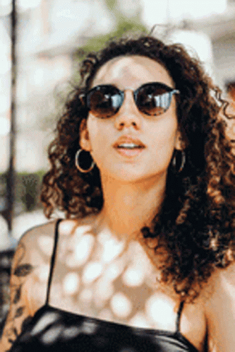 woman with sunglasses standing outside in the sun