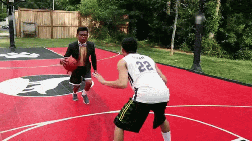 a man is playing basketball and the ball is just coming toward him