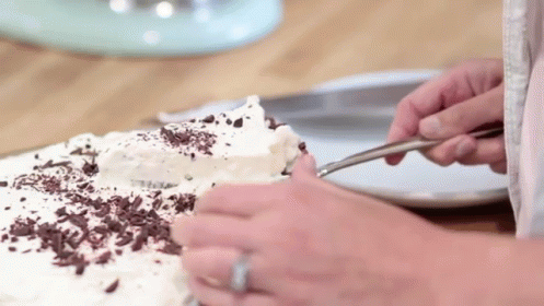 the woman is slicing and decorating her cake