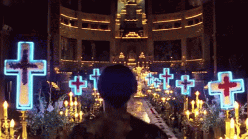 a man standing in front of some illuminated crosses