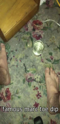 a blue plastic cup on the floor next to some feet