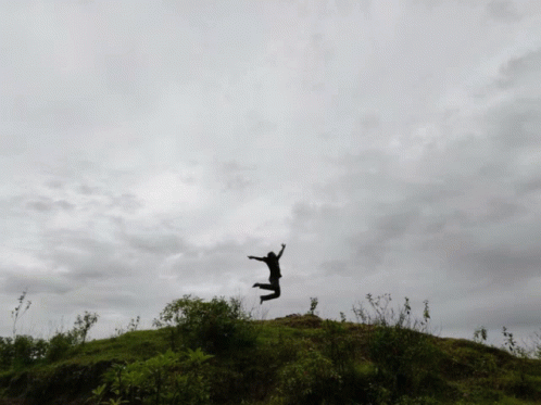 a person jumping high into the air near the sky