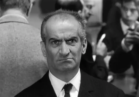 an older man in a black suit looking concerned