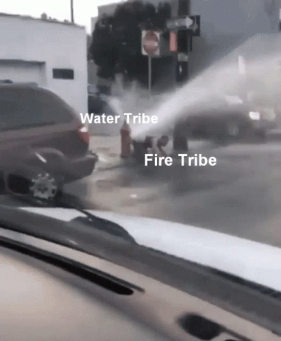a fire hose is spewing water onto a car parked on the street