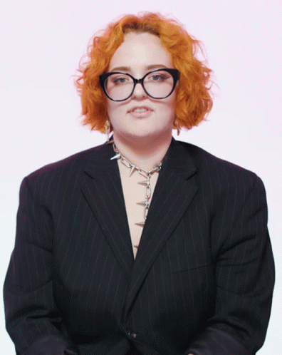 a woman with blue hair wearing glasses and a suit