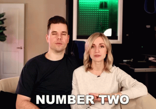 a man and a woman are sitting in a chair in front of a television with the words number two on it